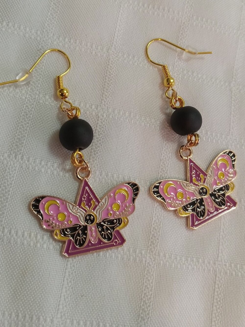 Handmade gold-colored earrings with multicolored enameled butterflies and beads